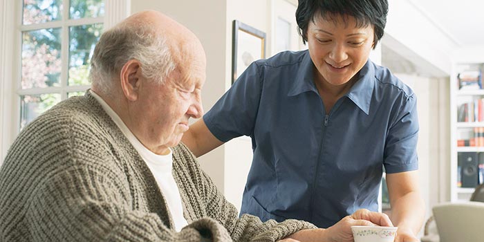 A support worker is seen engaging with a person who is elderly 